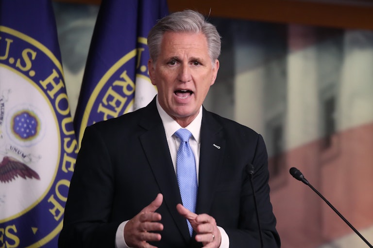 House Speaker Kevin McCarthy gestures with his hands and speaks at a podium. (He looks distressed.)
