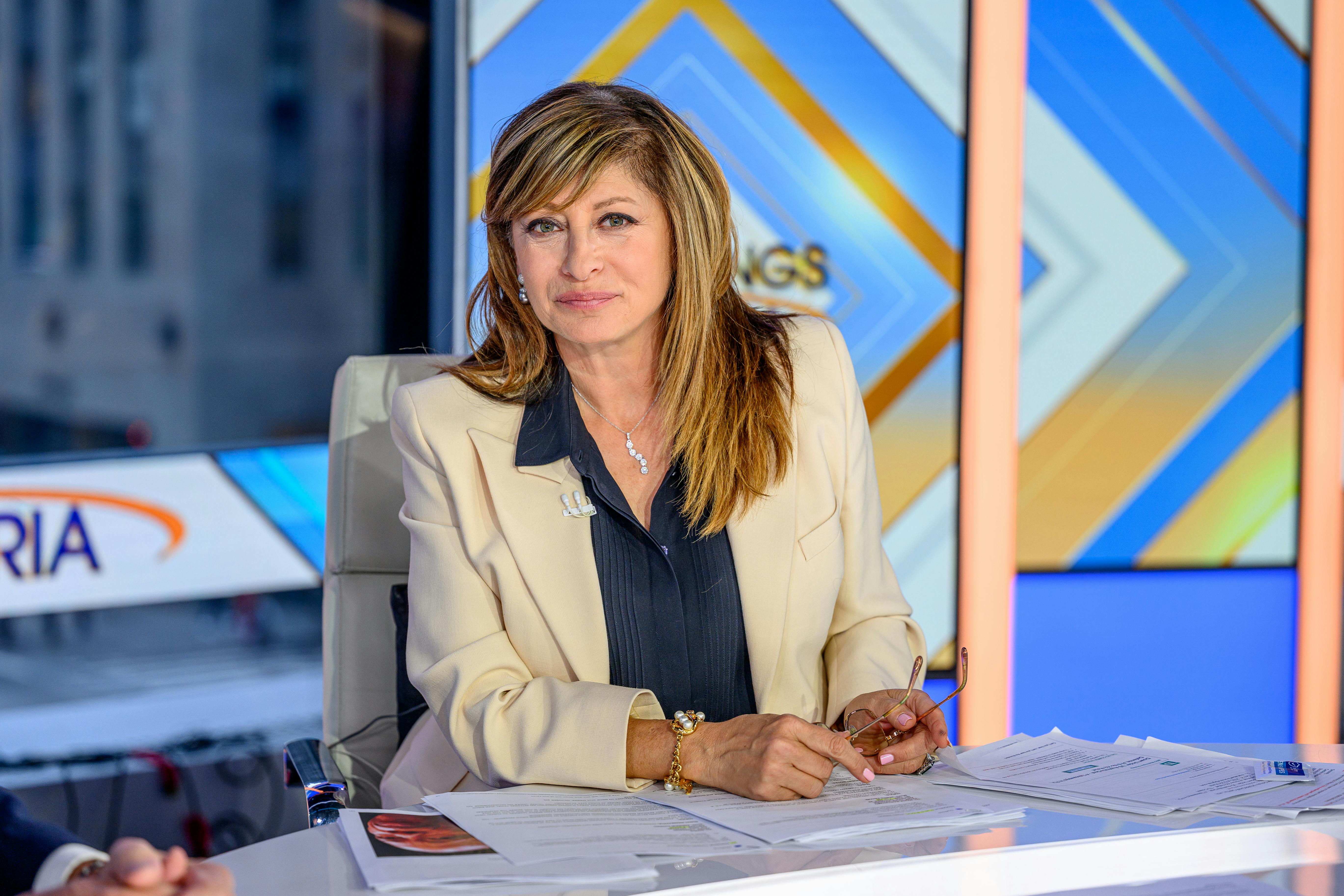 Maria Bartiromo, probably forgetting about something else, as she sits behind her Fox Business desk