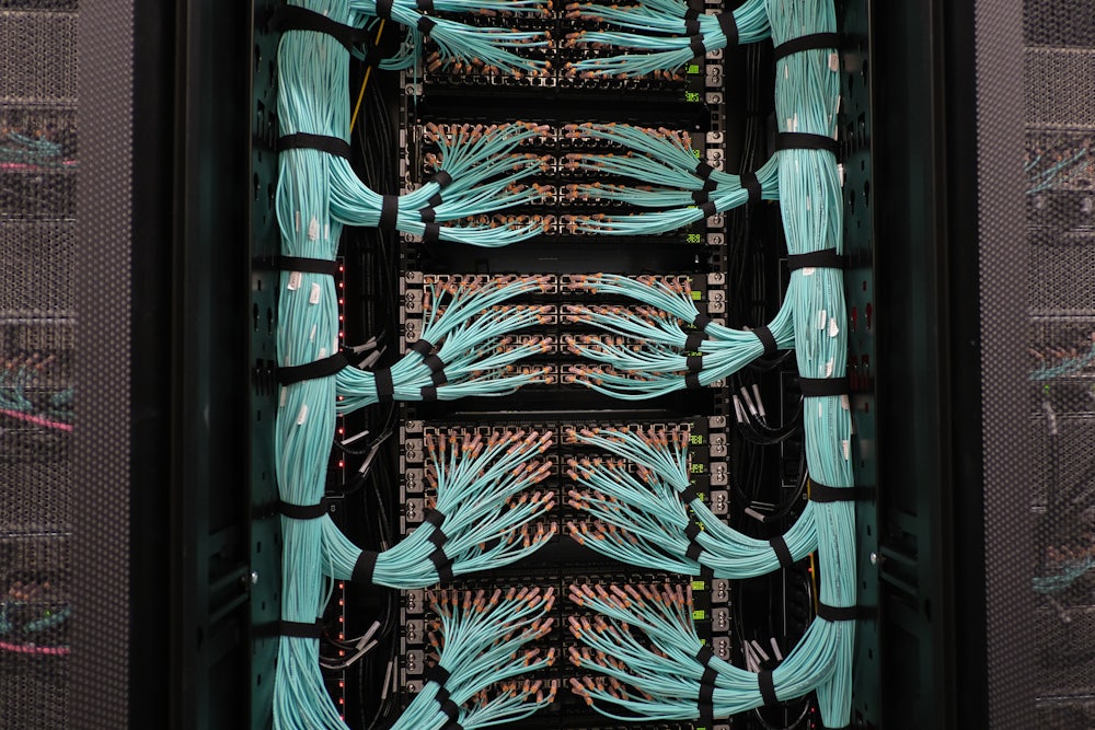 This picture shows bundles of wires connected to a supercomputer.