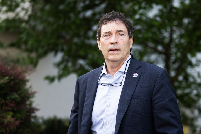 Representative Troy Balderson stands outside, his glasses hanging around his neck.
