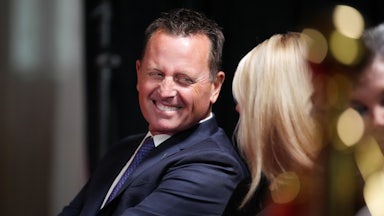 Kennedy Center interim Richard Grenell turns and laughs as he speaks with Pam Bondi, while they are seated at an event at the theater.