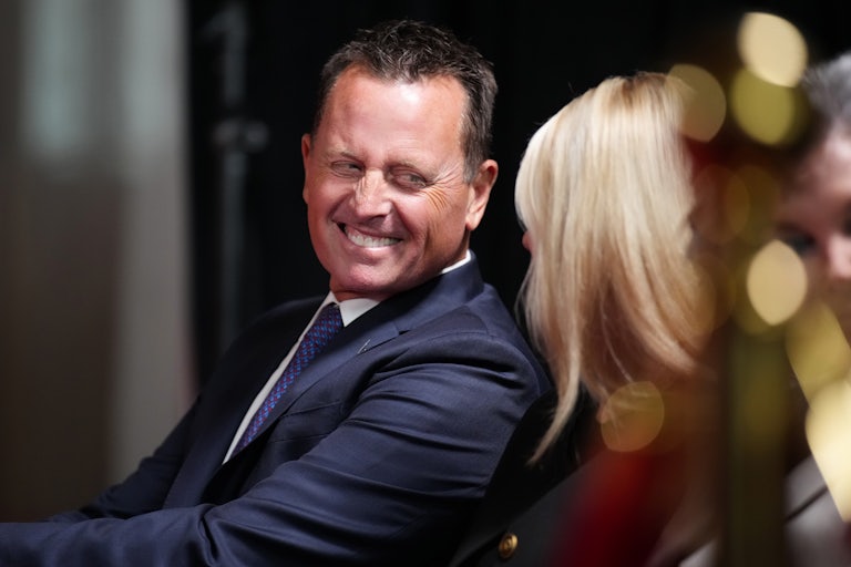Kennedy Center interim Richard Grenell turns and laughs as he speaks with Pam Bondi, while they are seated at an event at the theater.