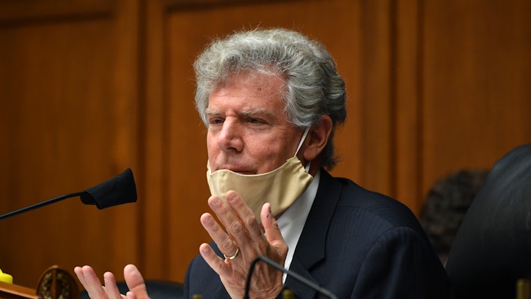 Frank Pallone speaks while seated, his face mask pulled down.