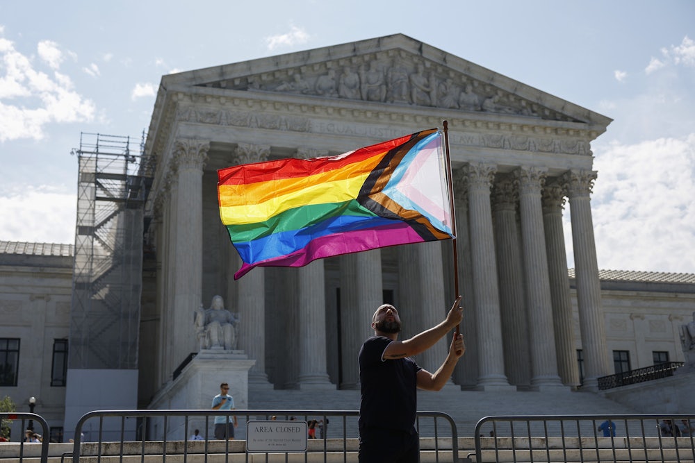 Vin Testa waves a LGBTQIA pride flag in front of the U.S. Supreme Court Building.