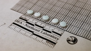 Suspected fentanyl tablets placed on a graph at a Drug Enforcement Administration lab.