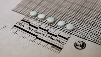 Suspected fentanyl tablets placed on a graph at a Drug Enforcement Administration lab.