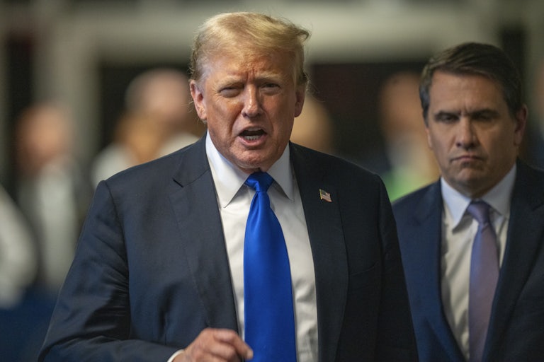 Donald Trump yells and points a finger. His lawyer Todd Blanche stands beside him.