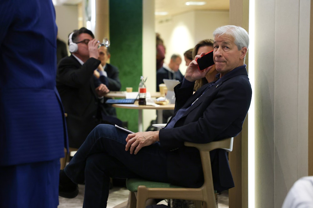 Jamie Dimon talks into a cell phone while seated.