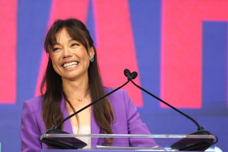 Nicole Shanahan stands standing at a podium with two mics