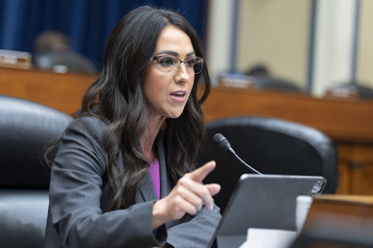 Lauren Boebert gestures while speaking into a microphone