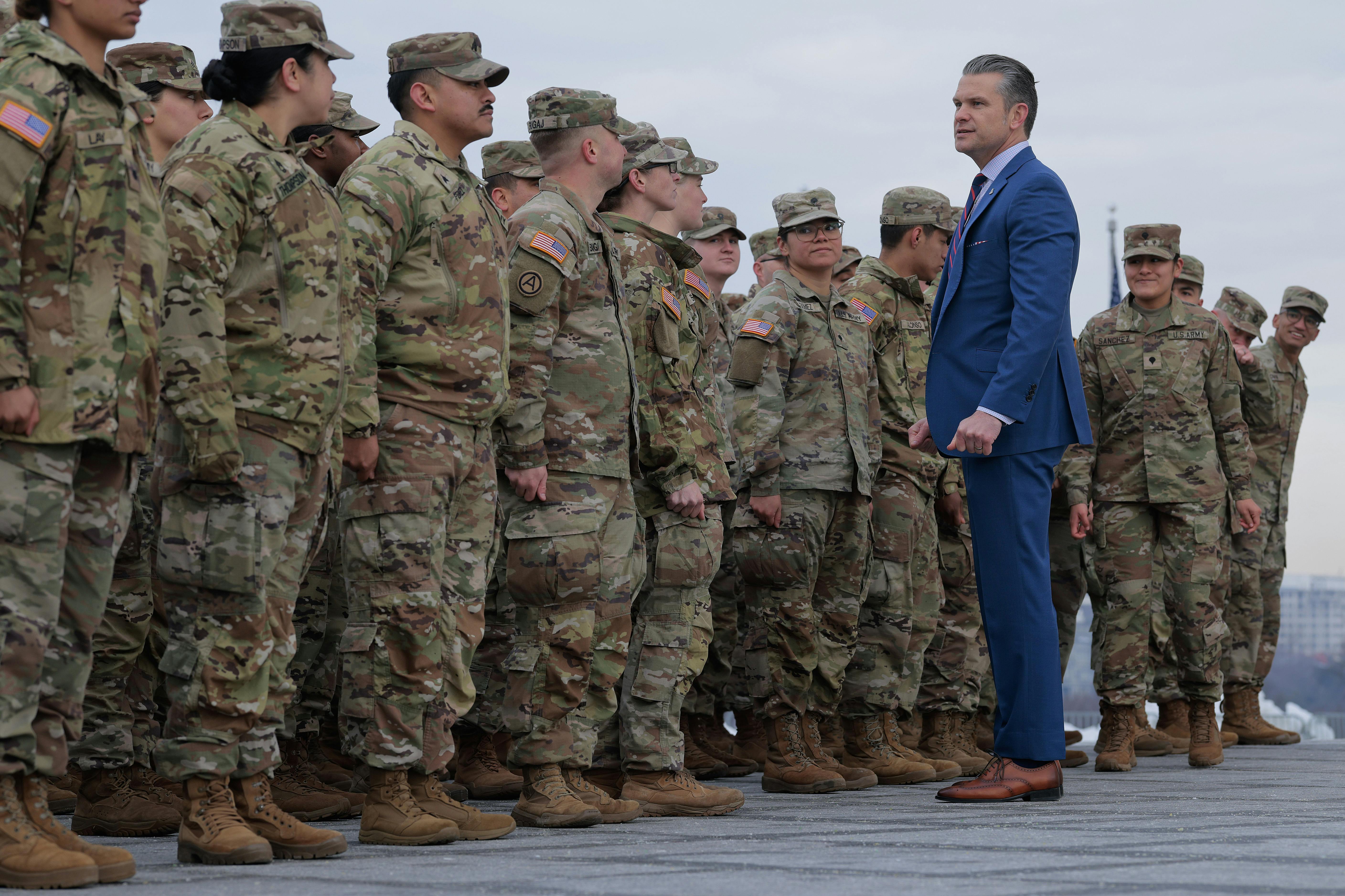 Secretary of War Pete Hegseth poses for photos with Army National Guard troops.