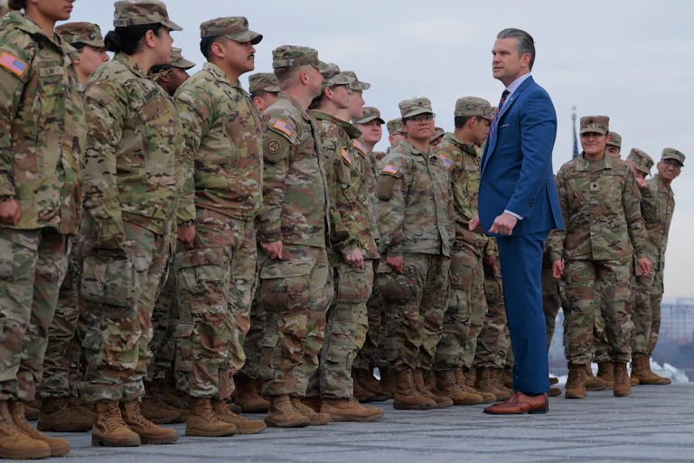 Secretary of War Pete Hegseth poses for photos with Army National Guard troops.
