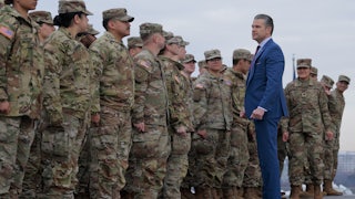 Secretary of War Pete Hegseth poses for photos with Army National Guard troops.