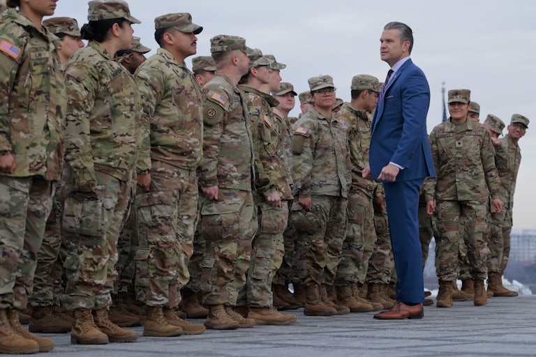 Secretary of War Pete Hegseth poses for photos with Army National Guard troops.