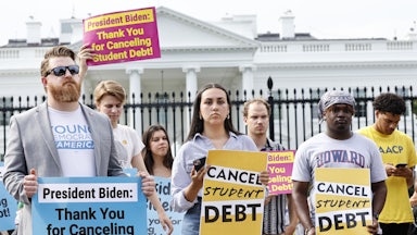 Demonstrators hold signs reading "CANCEL STUDENT DEBT" and "President Biden: Thank You for Canceling Student Debt."