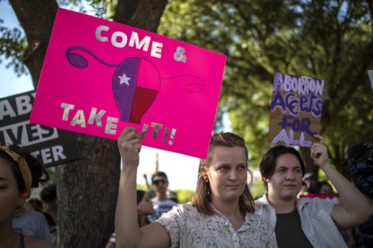 People hold up pro-abortion rights protest signs