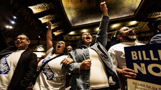 People wearing “Tax the Billionaires” shirts cheer at a Bernie Sanders–led rally in Los Angeles