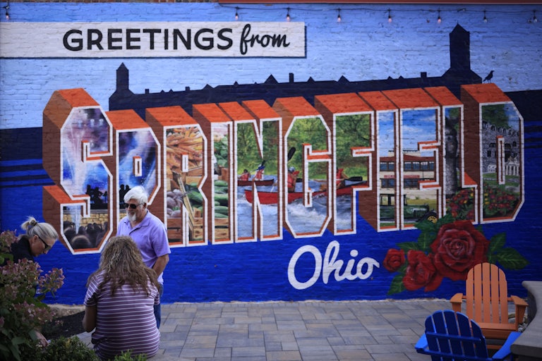 A wall with a mural that says "Greetings from Springfield Ohio"
