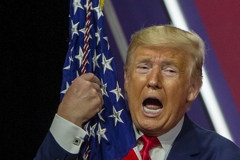 Donald Trump hugs the U.S. flag at the CPAC conference last year.