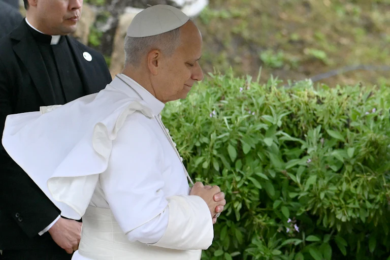 Pope Leo, seen in profile, stands with his eyes close and his hands folded in front of his stomach during a visit to an archaeological site in Algeria