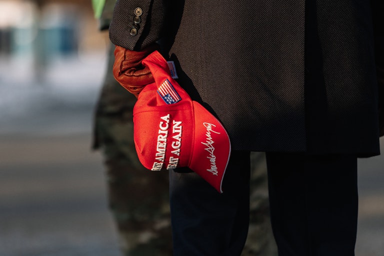 A gloved hand of a person holding a red "Make America Great Again" hat stands outside the U.S. Capitol on Inauguration Day on January 20, 2025.