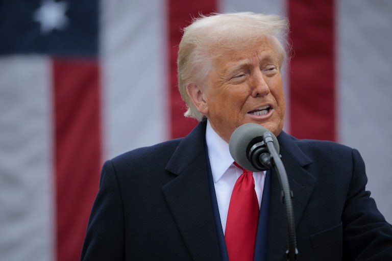 Donald Trump speaks at a mic outdoors.