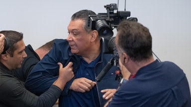 Multiple men push Democratic Senator Alex Padilla out of Homeland Security Secretary Kristi Noem's press conference. A cameraman captures it all.