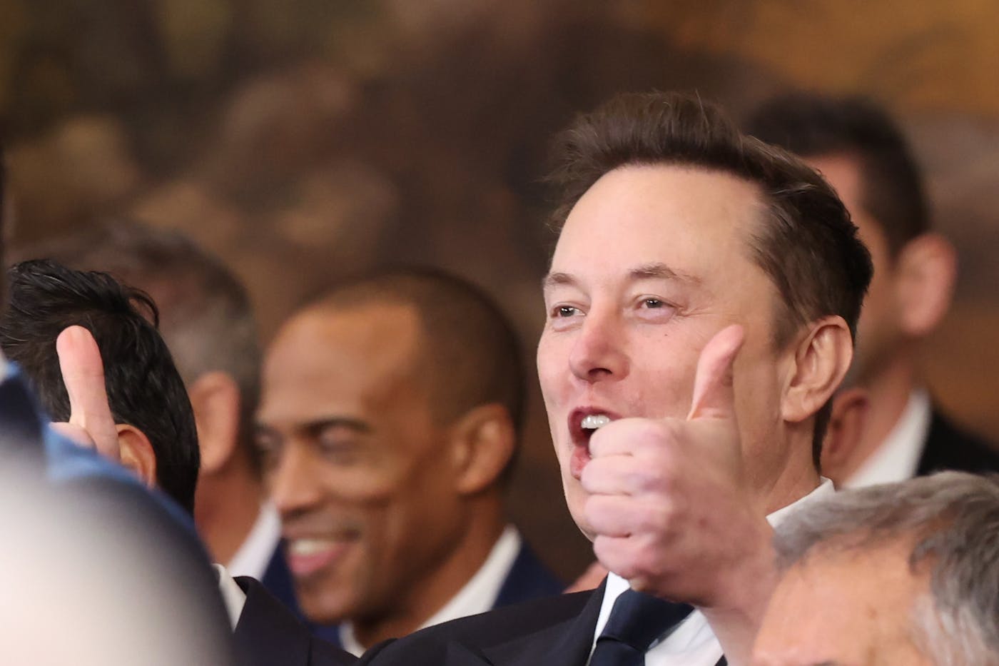 Elon Musk gives two thumbs up and cheers