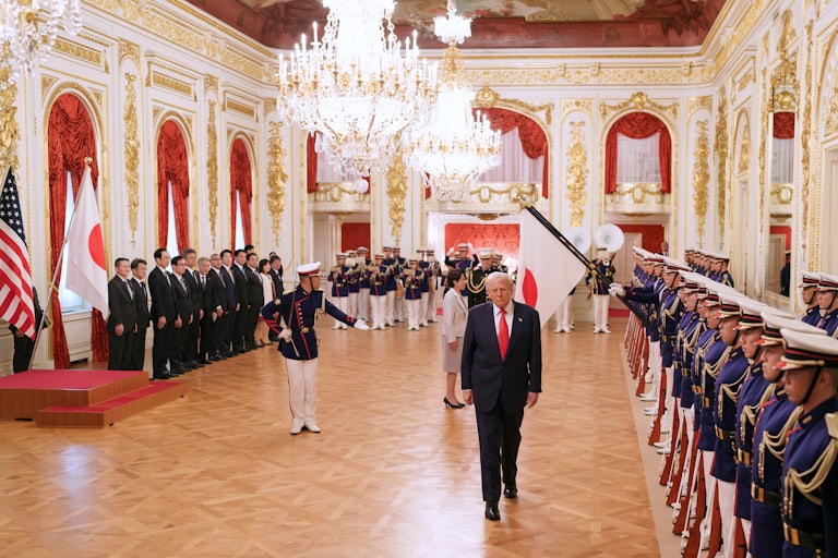 Donald Trump walks away from Japanese Prime Minister Sanae Takaichi as Japanese troops are lined up to greet them during a welcoming ceremony at Akasaka Palace.