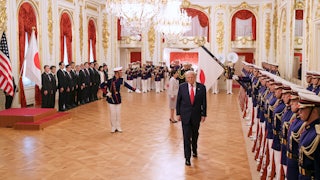 Donald Trump walks away from Japanese Prime Minister Sanae Takaichi as Japanese troops are lined up to greet them during a welcoming ceremony at Akasaka Palace.