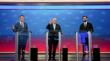Andrew Cuomo, Curtis Sliwa, and Zohran Mamdani stand at podiums onstage during the New York City mayoral debate