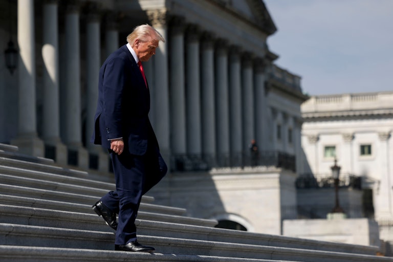 Donald Trump walks down steps outside the Capitol