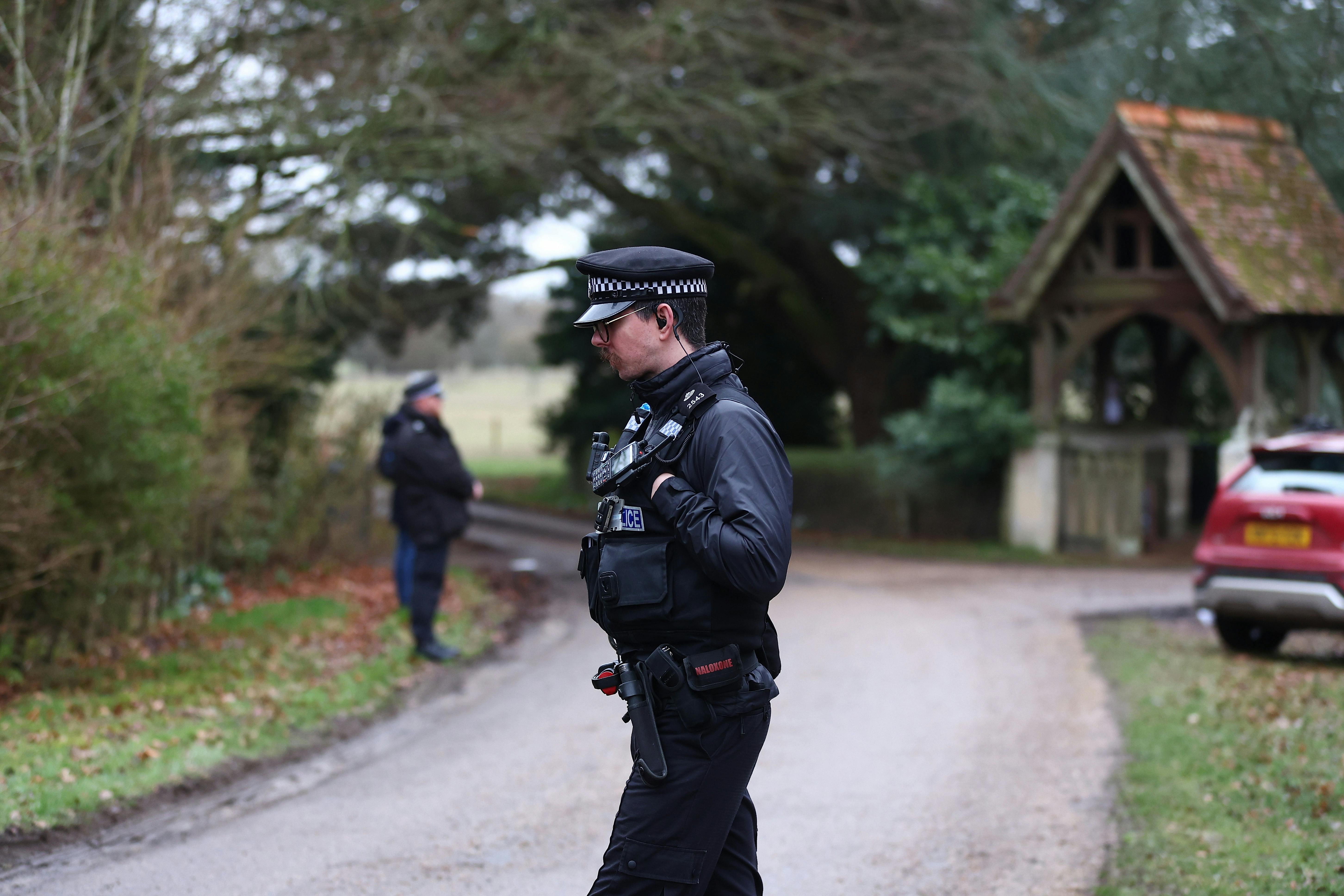 Police officers stand outside Andrew Mountbatten-Windsor’s home after his arrest