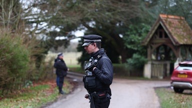Police officers stand outside Andrew Mountbatten-Windsor’s home after his arrest