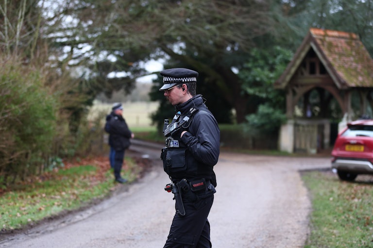 Police officers stand outside Andrew Mountbatten-Windsor’s home after his arrest