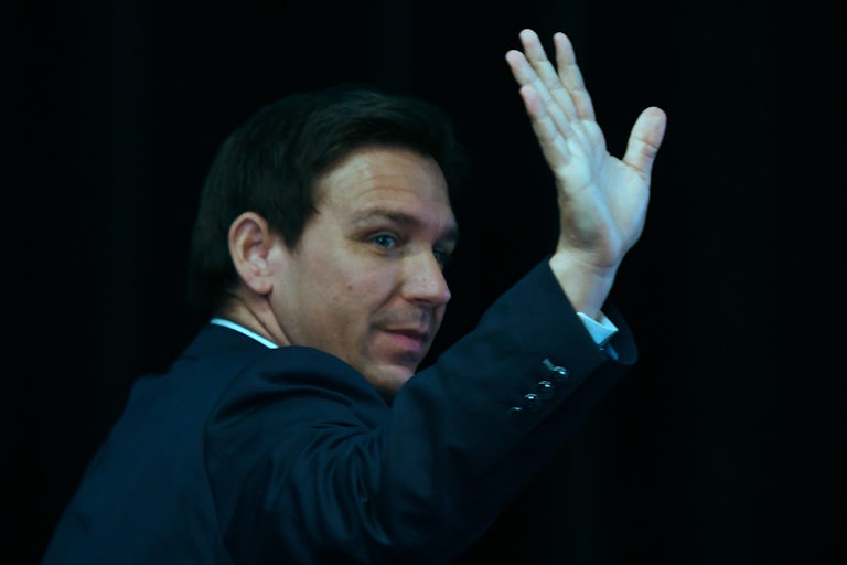 Florida Governor Ron DeSantis waves and looks over his shoulder