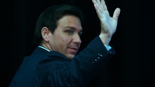 Florida Governor Ron DeSantis waves and looks over his shoulder