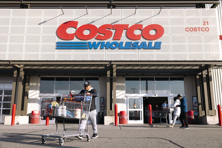 Shoppers with grocery carts in front of a Costco store.