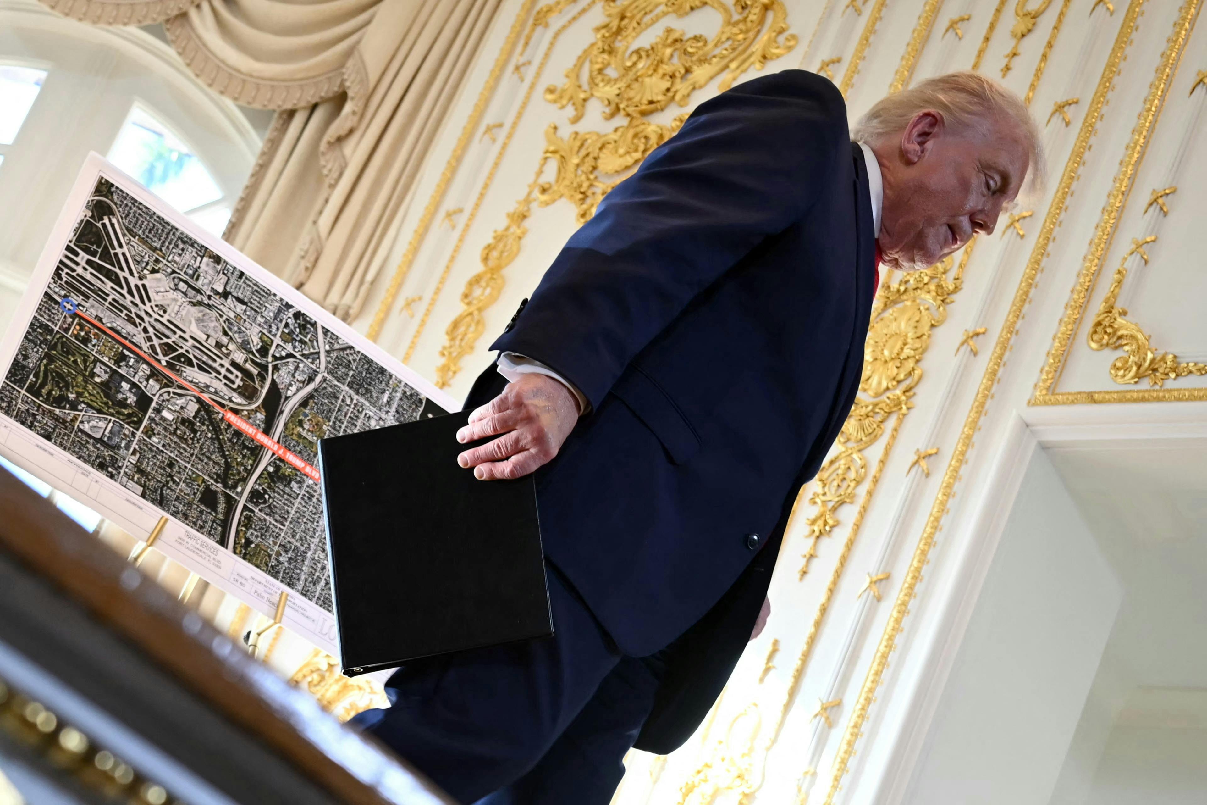 Donald Trump walks off the stage past a map.