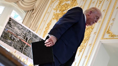 Donald Trump walks off the stage past a map.