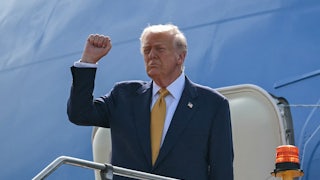 Donald Trump raises his fist as he exits Air Force One