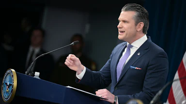Defense Secretary Pete Hegseth gestures and speaks at a podium
