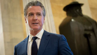 California Governor Gavin Newsom speaks to reporters while walking in the U.S. Capitol