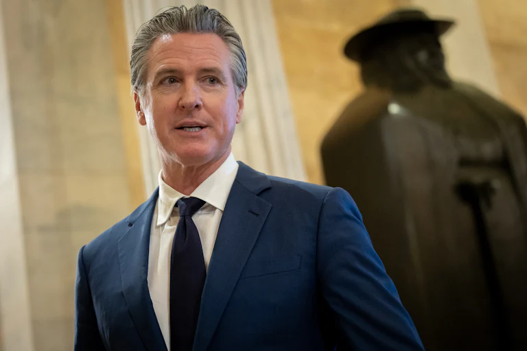 California Governor Gavin Newsom speaks to reporters while walking in the U.S. Capitol