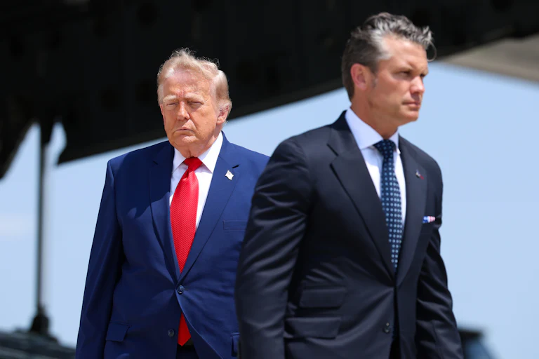 President Donald Trump walks in one direction while Defense Secretary Pete Hegseth walks in the other.