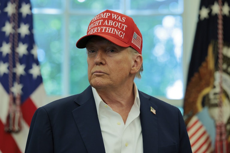 President Donald Trump sits in a chair in the Oval Office.
