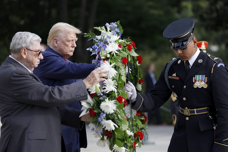 Donald Trump, Bill Barnett, and a U.S. service member touch a wreath at the Arlington National Cemetery