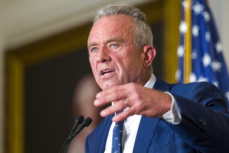Robert F. Kennedy Jr. gestures as he speaks into microphones