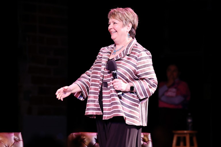 Janet Protasiewicz holds a microphone as she walks