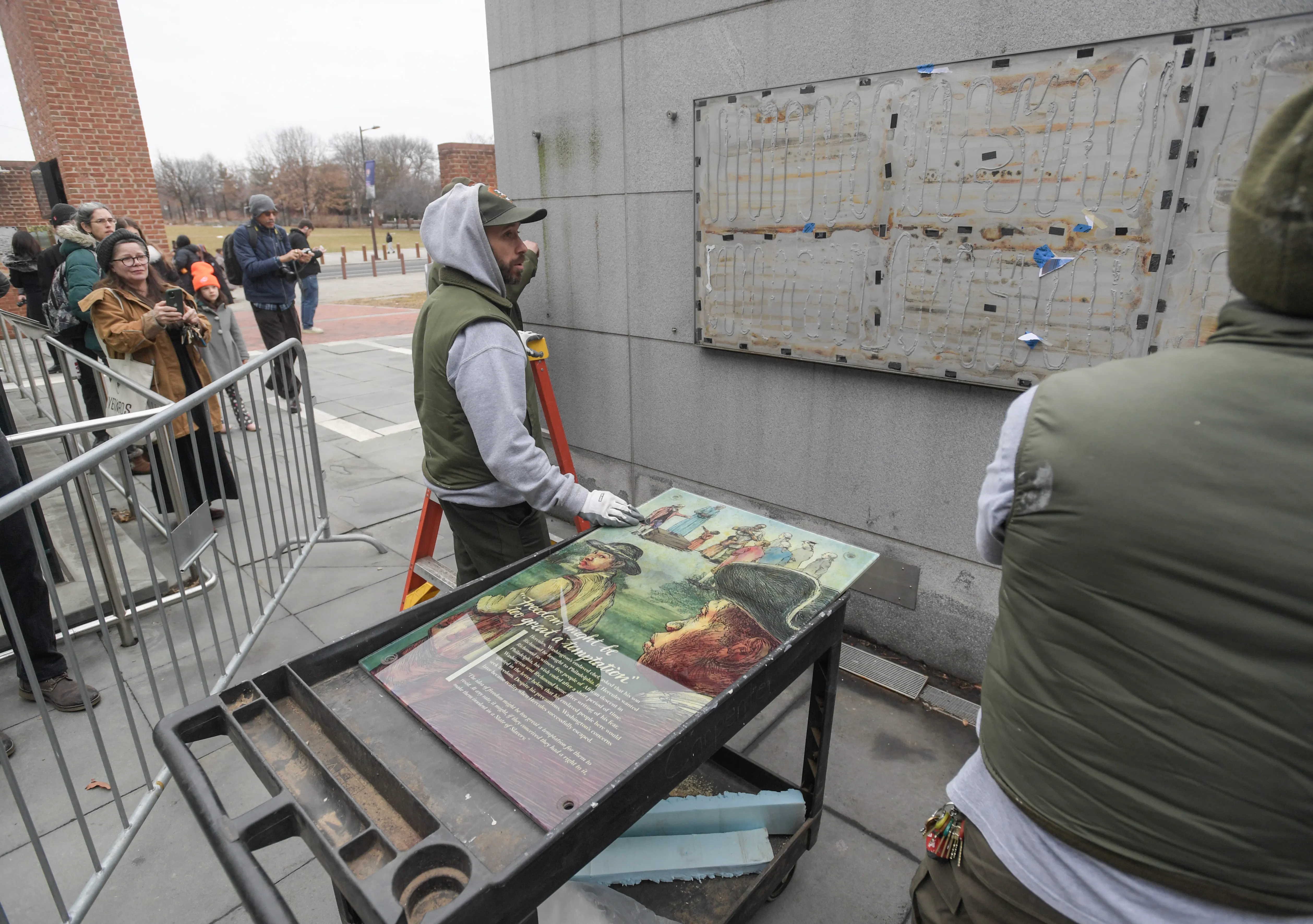 Staff with the National Parks Service replace the plaques that were part of the “Freedom and Slavery in the Making of a New Nation” exhibit at the President’s House